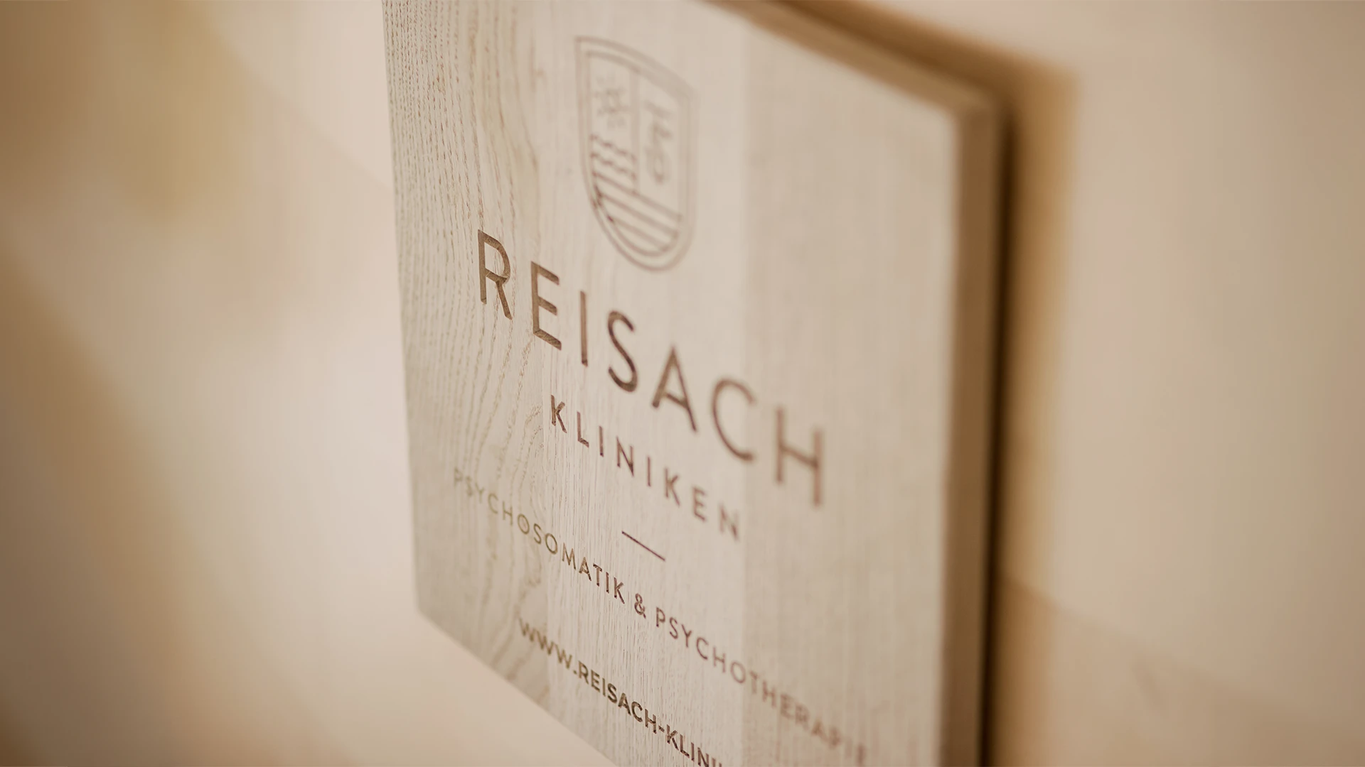 Holzschild mit dem Logo der Reisach Kliniken